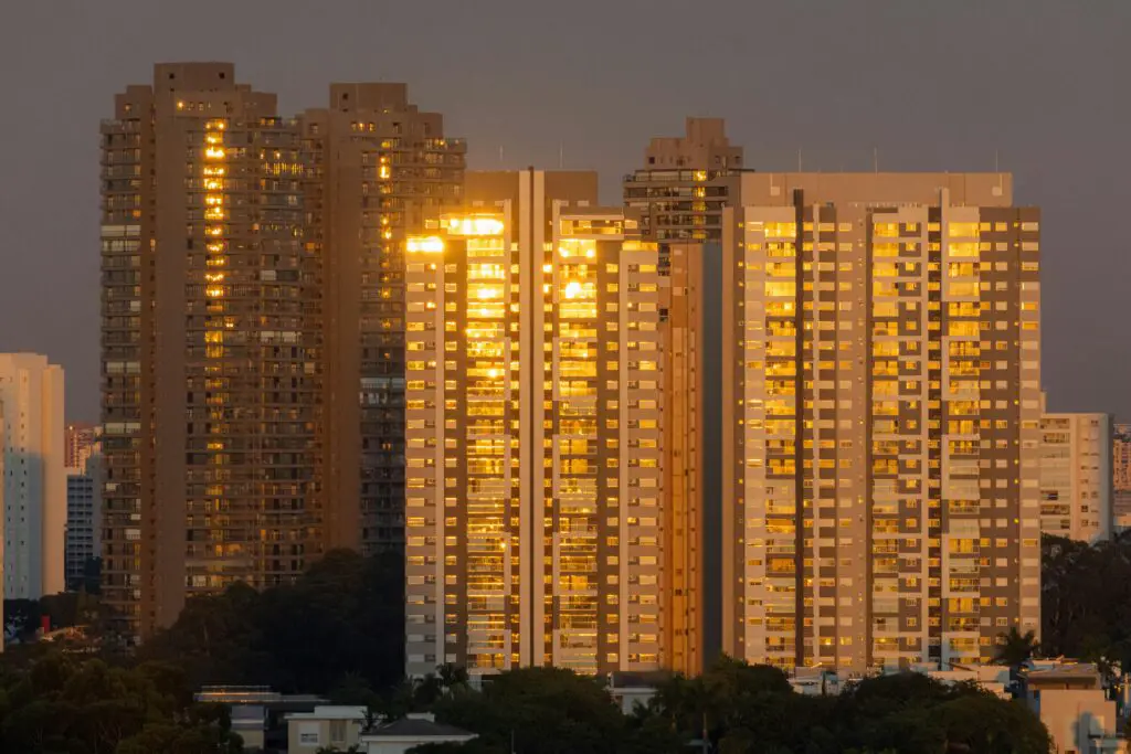 Golden sunset reflecting on high-rise buildings in São Paulo, Brazil's urban skyline.